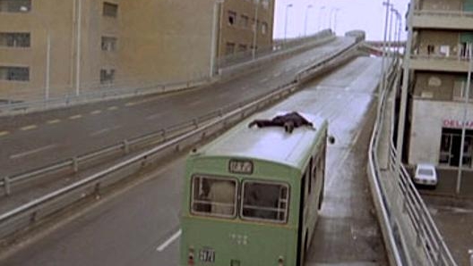 Fantozzi sull'autobus, sulla destra il palazzo dal quale si lancia sul mezzo pubblico