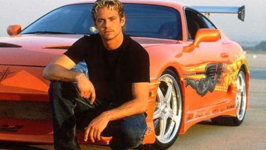 Paul Walker sul set del primo Fast and Furious, con la celebra Toyota Supra arancione