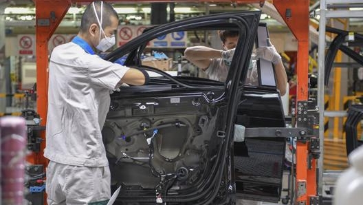 Operai al lavoro nell’impianto di Changchun su una Audi A6 L. Ap