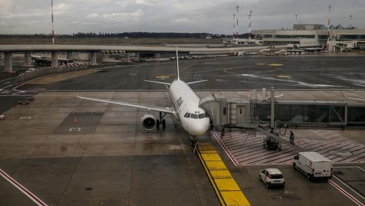 Un aereo attaccato al finger a Fiumicino sotto un cielo minaccioso. LaPresse/Fabiano