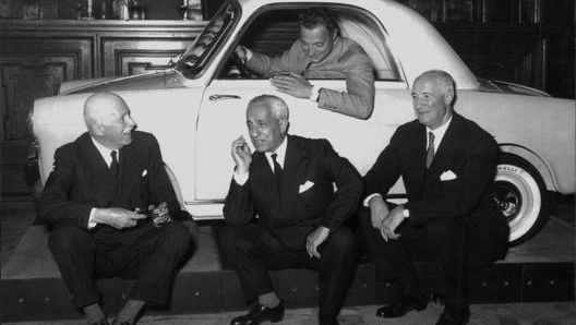 Gianni Agnelli nel 1957 al volante della Bianchina, durante la presentazione della vetturetta a Milano. Seduti, da sinistra: Alberto Pirelli, Vittorio Valletta e Giuseppe Bianchi. Publifoto