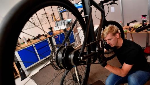 Un meccanico al lavoro su una e-bike. Afp