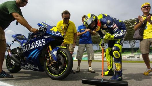 Rossi pulisce la pista in Malesia dopo la vittoria nel 2004. Milagro