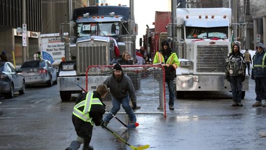 I manifestanti improvvisano partite di hockey sull’asfalto ghiacciato per combattere le temperature rigide