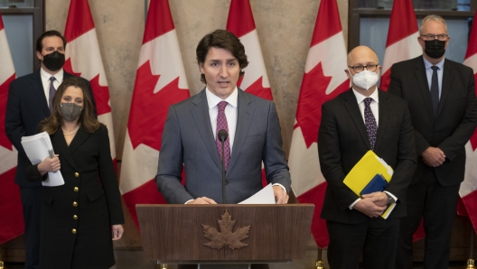 Public Safety Minister Marco Mendicino, Deputy Prime Minister and Finance Minister Chrystia Freeland, Justice Minister and Attorney General of Canada David Lametti and President of the Queen's Privy Council for Canada and Emergency Preparedness Minister Bill Blair stand behind Prime Minister Justin Trudeau as he announces the Emergencies Act will be invoked to deal with protests, Monday, Feb. 14, 2022 in Ottawa. Trudeau says he has invoked the act to bring to an end antigovernment blockades he describes as illegal. (Adrian Wyld/The Canadian Press via AP)