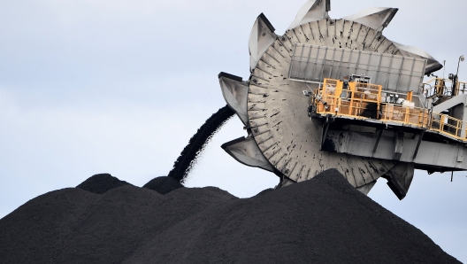 TOPSHOT - This picture taken on November 5, 2021 shows a bucket-wheel dumping soil and sand removed from another area of the mine in Newcastle, the world's largest coal exporting port. - Australia's conservative leaders have defied calls for urgent climate action, boasting they will sell coal for as long as anyone is buying, but in the country's carbon heartland, locals are already preparing for life beyond fossil fuels. (Photo by Saeed KHAN / AFP) / TO GO WITH UN-climate-COP26-Australia-coal,FOCUS by Andrew LEESON