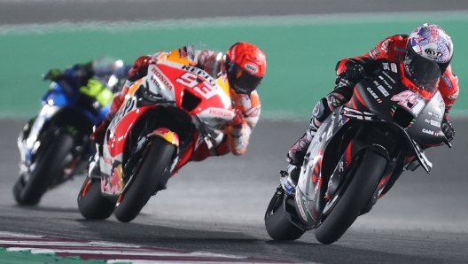 Aprilia Racing Team Gresini's Spanish rider Aleix Espargaro (R) and Repsol Honda Team's Spanish rider Marc Marquez (C) compete during the Moto GP Grand Prix of Qatar at the Lusail International Circuit, in the city of Lusail on March 6, 2022. (Photo by KARIM JAAFAR / AFP)