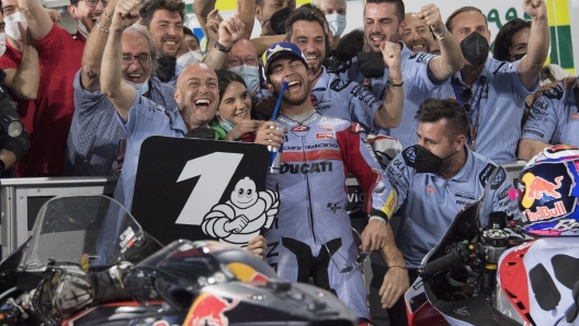 DOHA, QATAR - MARCH 06: Enea Bastianini of Italy and Gresini Racing MotoGP celebrates the victory with team under the podium during the MotoGP race during the MotoGP of Qatar at Losail Circuit on March 06, 2022 in Doha, Qatar. (Photo by Mirco Lazzari gp/Getty Images,)