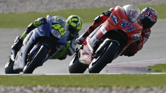 epa00952736 Australian MotoGP pilot Casey Stoner on Ducati (R) precedes Italian Yamaha pilot Valentino Rossi on his way to winning the Grand Prix of Qatar on the Losail International Circuit near Doha, Qatar, Saturday, 10 March 2007. Stoner won a close race ahead of Italian Yamaha pilot Valentino Rossi.  ANSA EPA/ALESSANDRO DELLA VALLE CD