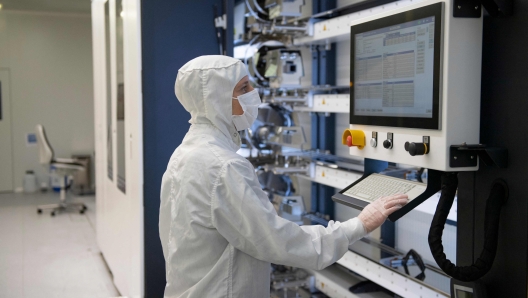 An employee works in the chip manufacturing process at the Barcelona Institute for Microelectronics (IMB-CNM) in Bellaterra, near Barcelona, on March 3, 2022. - The Institute of Microelectronics of Barcelona (IMB-CNM) is the largest institute in Spain dedicated to the research and development of Micro and Nano Technology (MNTs) and microsystems, and with unique capacities of silicon semiconductor technology. It belongs to the Spanish National Research Council (CSIC) since its foundation in 1985. (Photo by Josep LAGO / AFP)