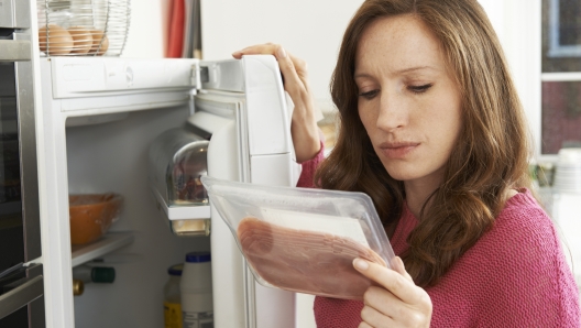 una donna legge la data di scadenza su un alimento confezionato