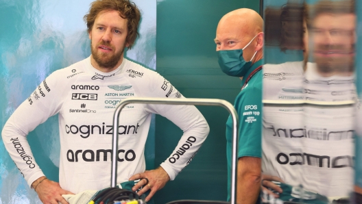 Aston Martin's German driver Sebastian Vettel (L) speaks with a team member during the second day of Formula One (F1) pre-season testing at the Bahrain International Circuit in the city of Sakhir on March 11, 2022. (Photo by Giuseppe CACACE / AFP)