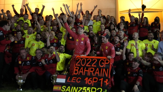 Ferrari driver Charles Leclerc of Monaco, left, and Ferrari driver Carlos Sainz of Spain pose for photograph with team members celebrating winning the first and second positions during the Bahrain Formula One Grand Prix at the Formula One Bahrain International Circuit in Sakhir, Bahrain, Sunday, March 20, 2022. (AP Photo/Hassan Ammar)