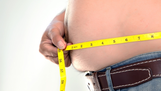 Obese person measuring his belly.