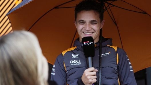 McLaren driver Lando Norris of Britain speaks with a journalist as he arrives in the paddock at the Dino and Enzo Ferrari racetrack, in Imola, Italy, Thursday, April 21, 2022. Italy's Emila Romagna Formula One Grand Prix will take place on Sunday. (AP Photo/Luca Bruno)