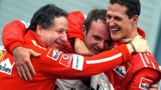 SCHUMACHER CON TODT E BARRICHELLO -German driver Michael Schumacher of Ferrari celebrates with the team's General Director Jean Todt (L) and Brazilian team-mate Rubens Barrichello (C) after clinching the driver's title following the Japanese Formula One Grand Prix in Suzuka, Sunday 12 October 2003. Schumacher placed 8th today, winning a record sixth world championship title. Barrichello won today's race. ANSA /KAY NIETFELD/JI