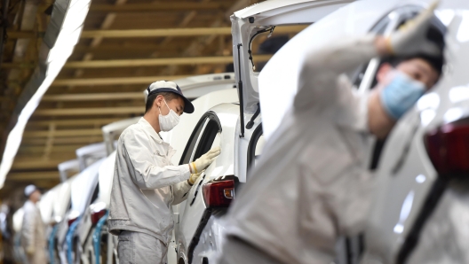 epa08299613 A masked man works on an assembly line at a Dongfeng Honda plant in Wuhan, Hubei province, China, 16 March 2020 (issued 17 March 2020). The joint venture is one of the first manufacturers allowed to resume operation in Wuhan after the coronavirus and COVID-19 outbreak.  EPA/SHEPHERD ZHOU CHINA OUT