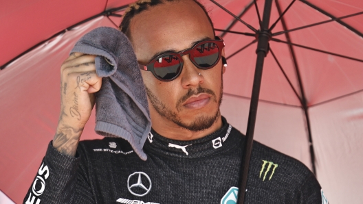 Mercedes driver Lewis Hamilton of Britain holds an umbrella prior to the start of the Azerbaijan Formula One Grand Prix at the Baku circuit, in Baku, Azerbaijan, Sunday, June 12, 2022. (Hamad Mohammed, Pool Via AP)