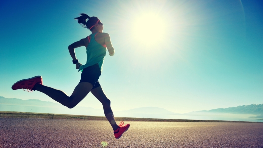 Una donna che corre con il sole in faccia