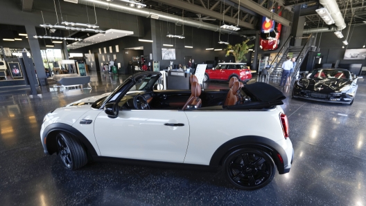 FILE - A sales associate talks with a prospective buyer of a Cooper SE electric vehicle on the showroom floor of a Mini dealership July 7, 2022, in Highlands Ranch, Colo. The surprise deal by Senate Democrats on a pared-down bill to support families, boost infrastructure and fight climate change is likely to jump start sales of electric vehicles. (AP Photo/David Zalubowski, File)