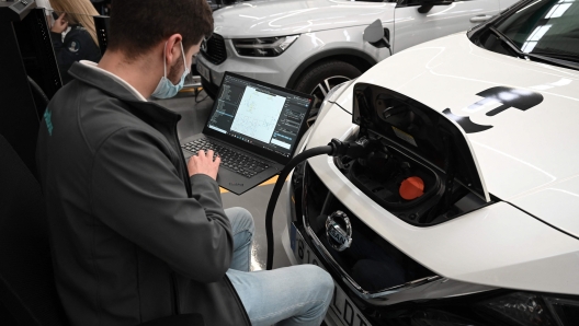 An employee works in the new plant of Wallbox company that develops charging stations for electric vehicles and homes, in Barcelona on April 20, 2022. (Photo by LLUIS GENE / AFP)