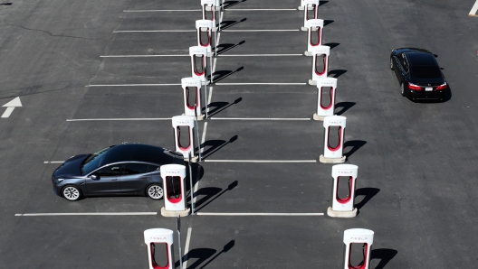 PETALUMA, CALIFORNIA - MARCH 09: In an aerial view, a Tesla car recharges its battery at the Petaluma Supercharger on March 09, 2022 in Petaluma, California. With oil prices continuing to soar, shares for companies in the electric vehicle sector are rising as consumers look to trade their gas powered cars in for electric vehicles.   Justin Sullivan/Getty Images/AFP == FOR NEWSPAPERS, INTERNET, TELCOS & TELEVISION USE ONLY ==