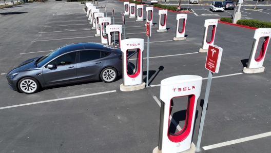 PETALUMA, CALIFORNIA - MARCH 09: In an aerial view, a Tesla car recharges its battery at the Petaluma Supercharger on March 09, 2022 in Petaluma, California. With oil prices continuing to soar, shares for companies in the electric vehicle sector are rising as consumers look to trade their gas powered cars in for electric vehicles.   Justin Sullivan/Getty Images/AFP == FOR NEWSPAPERS, INTERNET, TELCOS & TELEVISION USE ONLY ==