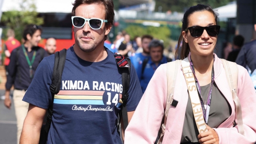 Alpine's Spanish driver Fernando Alonso (L) and  and his grirlfriend Austrian journalist Andrea Schlager walk to the Paddock ahead of the Spa-Francorchamps racetrack on August 25, 2022. - The Formula One Belgian Grand Prix will take place on August 28, 2022. (Photo by Kenzo TRIBOUILLARD / AFP)