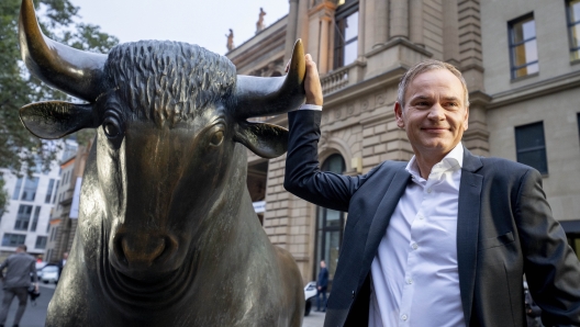 CEO of Porsche car maker Oliver Blume touches the bull statue at the start of Porsche's market listing at the stock market in Frankfurt, Germany, Thursday, Sept. 29, 2022. (AP Photo/Michael Probst)