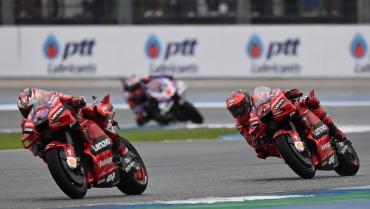 Ducati Lenovo's Australian rider Jack Miller (L) and Ducati Lenovo's Italian rider Francesco Bagnaia (R) compete during the MotoGP Thailand Grand Prix at the Buriram International Circuit in Buriram on October 2, 2022. (Photo by Manan VATSYAYANA / AFP)