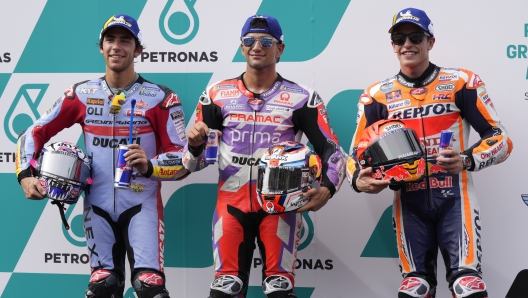 Italian rider Enea Bastianini of the Gresini Racing MotoGP, Spanish rider Jorge Martin of Prima Pramac Racing and Spanish rider Marc Marquez of Repsol Honda Team celebrate after the MotoGP qualifying round for the Malaysia Motorcycle Grand Prix in Sepang International Circuit, Saturday, Oct. 22, 2022. Martin took the pole position while Bastianini took second position, and Marquez third grid for the Sunday's race. (AP Photo/Vincent Thian)