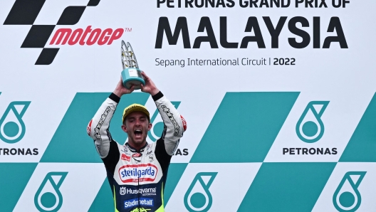 Sterilgarda Husqvarna Max's British rider John McPhee celebrates his victory on the podium for the Malaysian Grand Prix Moto3 race at the Sepang International Circuit in Sepang on October 23, 2022, ahead of the MotoGP Malaysian Grand Prix motorcycle race. (Photo by MOHD RASFAN / AFP)