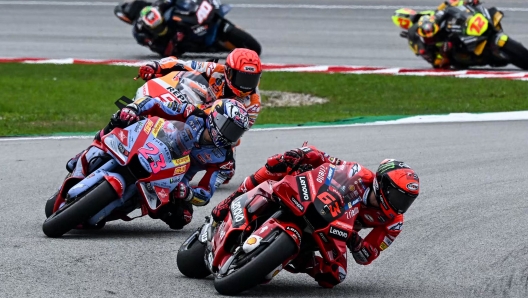 Ducati Lenovo's Italian rider Francesco Bagnaia speeds ahead of Ducati Gresini Racing's Italian rider Enea Bastianini and Repsol Honda's Spanish rider Marc Marquez during the MotoGP Malaysian Grand Prix motorcycle race at the Sepang International Circuit in Sepang on October 23, 2022. (Photo by MOHD RASFAN / AFP)