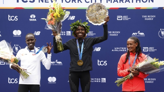 From left, women's division second place finisher Lonah Chemtai Salpeter, of Israel, winner Sharon Lokedi, of Kenya, and third place finisher Gotytom Gebreslase, of Ethiopia, pose during a ceremony at the finish line of the New York City Marathon, Sunday, Nov. 6, 2022, in New York. (AP Photo/Jason DeCrow)