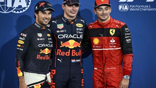 Red Bull's Mexican driver Sergio Perez (L) Red Bull's Dutch driver Max Verstappen (C) and Ferrari's Monegasque driver Charles Leclerc pose for a picture after the qualifying session on the eve of the Abu Dhabi Formula One Grand Prix at the Yas Marina Circuit in the Emirati city of Abu Dhabi on November 19, 2022. (Photo by Ben Stansall / AFP)