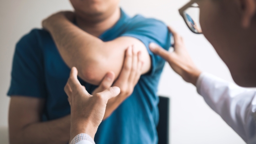 Physical therapists are checking patients elbows at the clinic office room.