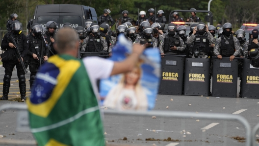 A protesters, supporter of Brazil's former President Jair Bolsonaro, in confronted by a police phalanx after the demonstrators stormed the Planalto Palace in Brasilia, Brazil, Sunday, Jan. 8, 2023. Planalto is the official workplace of the president of Brazil. (AP Photo/Eraldo Peres)