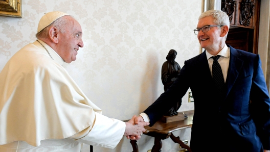 This handout photo taken on October 3, 2022 and released by the Vatican press office, the Vatican Media, shows Pope Francis (L) shaking hands with Apple CEO Tim Cook prior to a private audience at the Vatican. (Photo by Handout / VATICAN MEDIA / AFP) / RESTRICTED TO EDITORIAL USE - MANDATORY CREDIT "AFP PHOTO / VATICAN MEDIA " - NO MARKETING NO ADVERTISING CAMPAIGNS - DISTRIBUTED AS A SERVICE TO CLIENTS