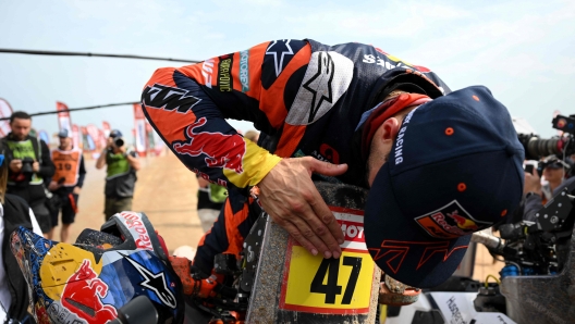 Argentina's biker Kevin Benavides kisses his bike after winning the Dakar Rally 2023 the Dakar Rally 2023, at the end of the last stage between between Al-Hofuf and Dammam, Saudi Arabia, on January 15, 2023. - Benavides won the Dakar Rally motorbike title for a second time as the historic endurance race came to an end on Sunday in Dammam, Saudi Arabia. The 34-year-old 2021 champion edged out Australian Toby Price by 43 seconds with Skyler Howes of the United States finishing third according to race organisers Amaury Sport Organisation (ASO). (Photo by FRANCK FIFE / AFP)