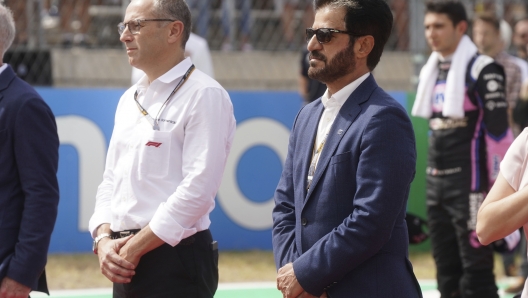 FIA president Mohammed bin Sulayem, right, stands during a tribute for Red Bull team owner Dietrich Mateschitz before the F1 U.S. Grand Prix auto race at Circuit of the Americas, Sunday, Oct. 23, 2022, in Austin, Texas. (AP Photo/Shawn Thew, Pool)