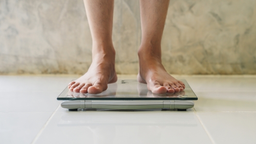 Male on weight scale on floor background, Diet concept.