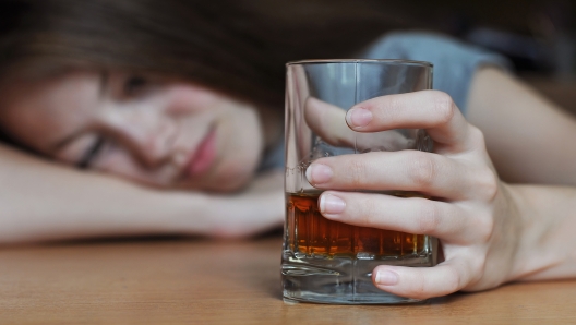 Drunk female with a glass of whiskey