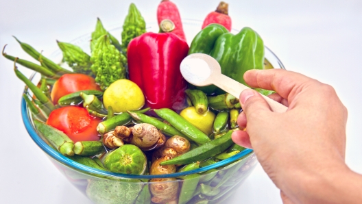 Washing and soaking fresh market vegetables in a water and baking soda solution to safely remove pesticide and other chemical residues.