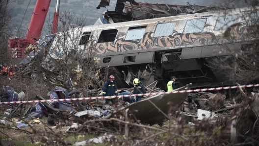 Police and emergency crew search the debris of a crushed wagon after a train accident in the Tempi Valley near Larisa, Greece, March 1, 2023. - At least 29 people were killed and another 85 injured after a collision between two trains caused a derailment near the Greek city of Larissa late Tuesday night, February 28, 2023, authorities said. A fire services spokesman confirmed that three carriages skipped the tracks just before midnight after the trains -- one for freight and the other carrying 350 passengers - collided about halfway along the route between Athens and Thessaloniki. (Photo by Sakis MITROLIDIS / AFP)