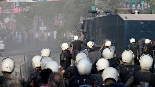 Riot police use water cannon to push back supporters of former prime minister Imran Khan gathered outside Khan's house to prevent officers from arresting him, in Lahore on March 14, 2023. (Photo by Arif ALI / AFP)