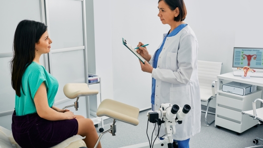 Young woman during appointment with mature gynecologist at gynecology clinic. Women's health, examination of uterus and ovarian