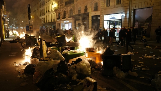 FILE - Piles of uncollected garbage is set on fire by protesters after a demonstration near Concorde square, in Paris, March 16, 2023. (AP Photo/Lewis Joly, File)