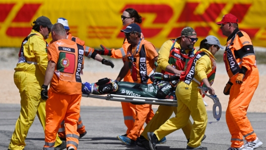 Track staff members carry Aprilia Portuguese rider Miguel Oliveira on a stretcher after crashing during the MotoGP race of the Portuguese Grand Prix at the Algarve International Circuit in Portimao, on March 26, 2023. (Photo by PATRICIA DE MELO MOREIRA / AFP)