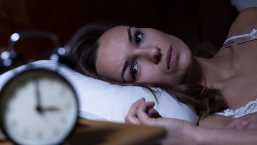 Woman lying in bed suffering from insomnia