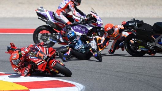 Honda Spanish rider Marc Marquez (R) crashes with Aprilia Portuguese rider Miguel Oliveira (C) as Ducati Italian rider Francesco Bagnaia (L) rides past during the MotoGP race of the Portuguese Grand Prix at the Algarve International Circuit in Portimao, on March 26, 2023. (Photo by PATRICIA DE MELO MOREIRA / AFP)